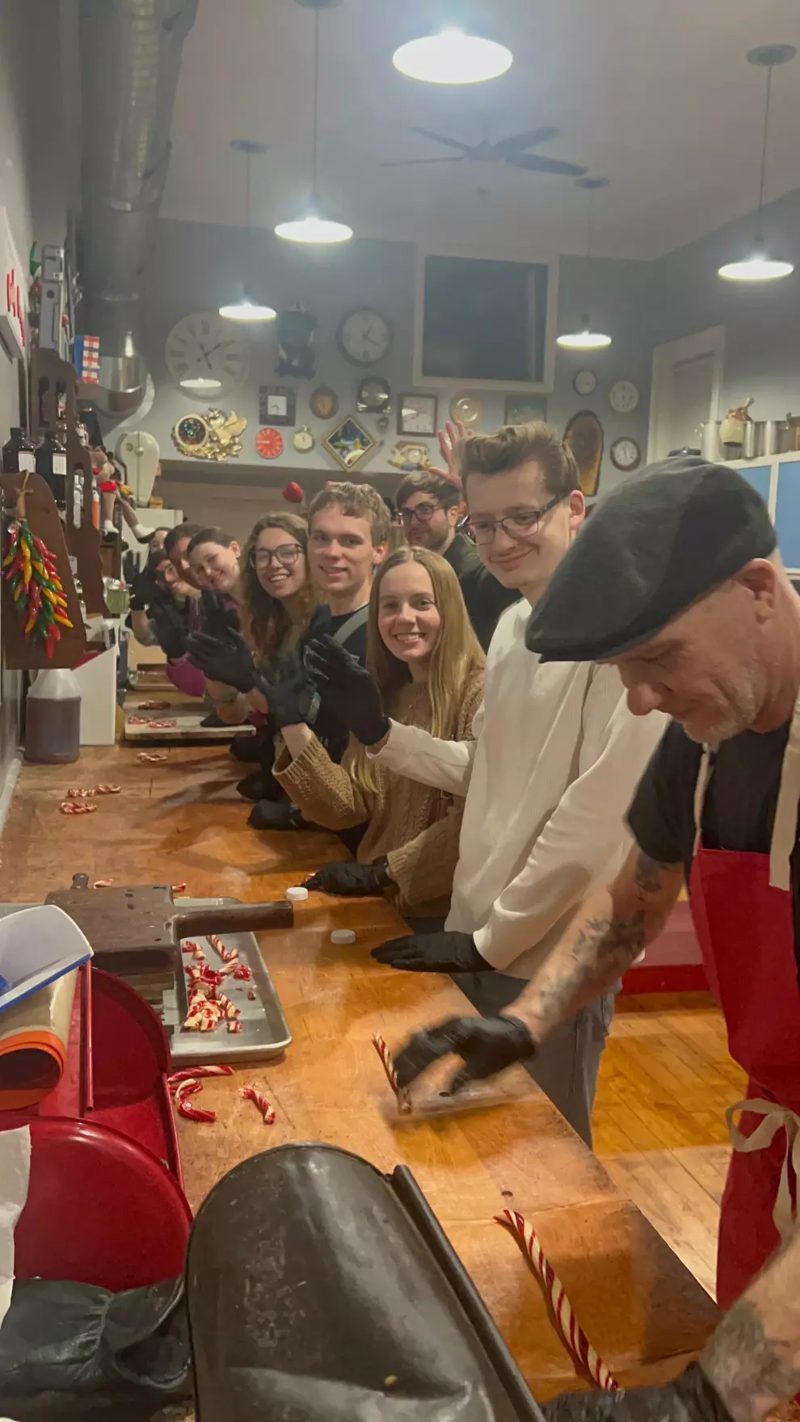 Guests gathered along the candy kitchen's long work table